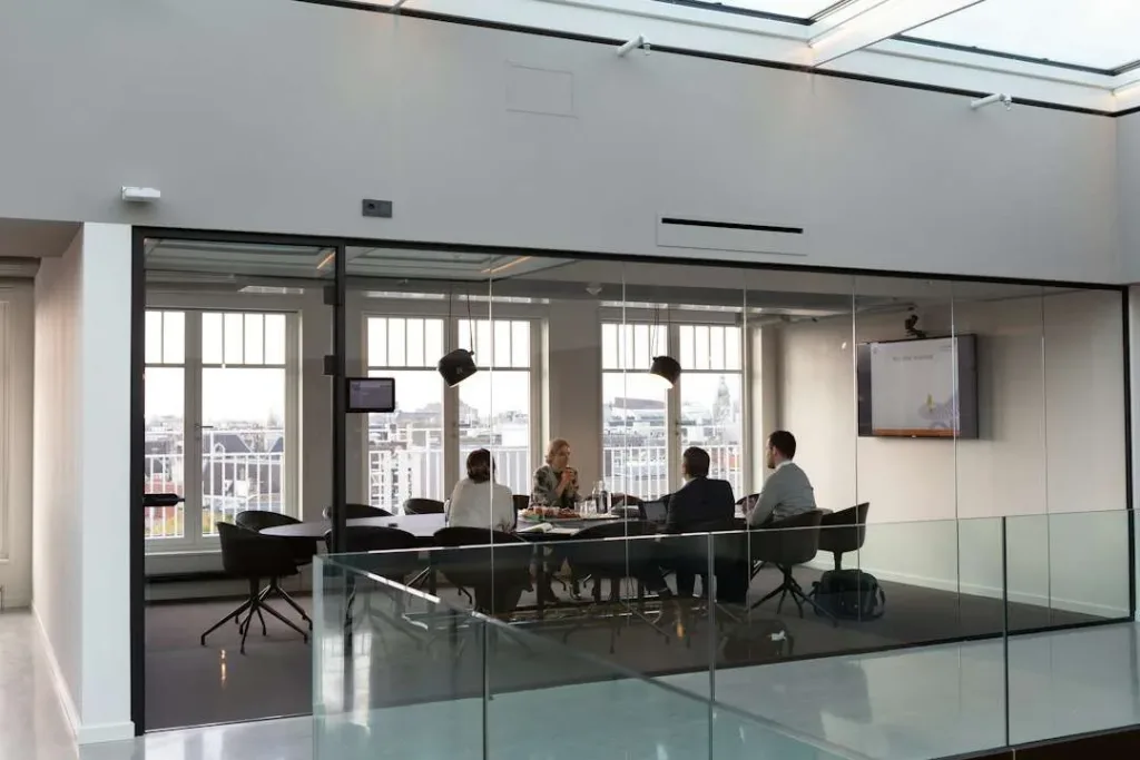 Professionals discussing work around a meeting table — illustrative stock photograph
